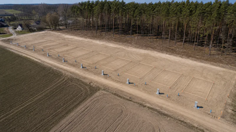 Wyrównany i uporządkowany teren podzielony na działki z oznaczonymi granicami
